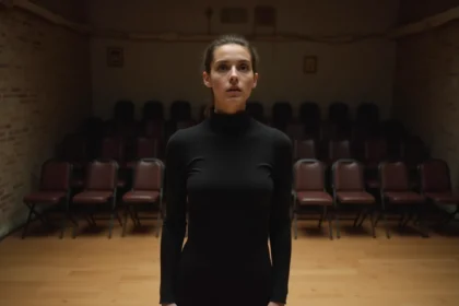 Jeune comédienne répétant un monologue seule sur scène dans une salle de théâtre intimiste à Paris